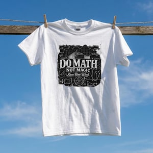 Può includere: Una t-shirt bianca a maniche corte con una grafica rettangolare nera sul petto. La grafica mostra varie formule matematiche e forme geometriche con il testo bianco DO MATH NOT MAGIC SHOW YOUR WORK stampato al centro.