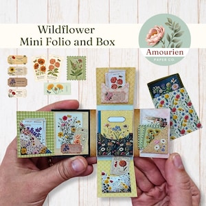 May include: A miniature Wildflower Mini Folio and Box, with floral designs and the text "Wildflower Mini Folio and Box." The box is open, revealing compartments with floral-themed cards and pockets. The design includes various floral stamps and tags.