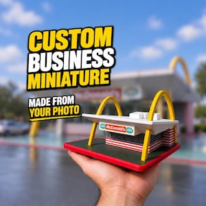 May include: A miniature model of a McDonald's restaurant building featuring a white roof, yellow arches, and red and white striped walls, mounted on a green and red base. Text overlay reads: CUSTOM BUSINESS MINIATURE MADE FROM YOUR PHOTO.