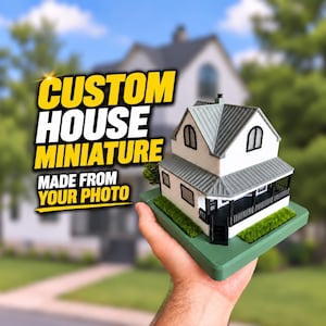 May include: A miniature house model with white walls, a gray roof, and a black porch railing, mounted on a green base. The text CUSTOM HOUSE MINIATURE MADE FROM YOUR PHOTO is displayed in bold yellow and white lettering to the left of the model.