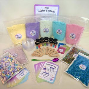 Pode incluir: Um kit Potion Party com vários pós coloridos em bolsas transparentes rotuladas como PlayFill, incluindo amarelo, roxo, menta, azul e rosa. Inclui pequenas colheres de madeira, copos de plástico transparentes, frascos de vidro e cartões.