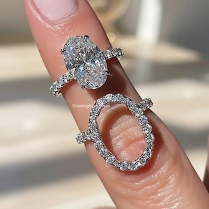 Peut inclure: Deux bagues argentées aux motifs ovales. La bague supérieure présente une grande pierre ovale centrale avec un anneau pavé, tandis que la bague inférieure est un cadre ovale ouvert incrusté de petites pierres claires. Le texte GoldengleamJewel est visible.