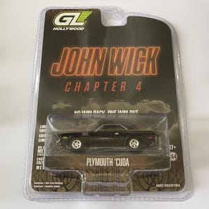 Puede incluir: Un coche modelo Plymouth 'Cuda negro de la película John Wick: Capítulo 4, en un embalaje de plástico transparente. El embalaje presenta el título de la película y el texto "Adult Collectible."