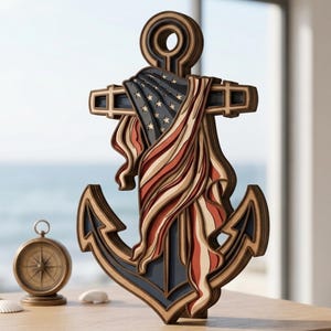 May include: A layered wooden anchor sculpture featuring a draped American flag design with red, white, and blue tones. The anchor has a circular top ring and pointed flukes. A small, round, metallic compass sits to the left of the anchor.