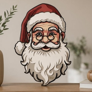 May include: A layered wooden wall art piece depicting the face of Santa Claus with a red hat, white beard, and round glasses. The design features a multi-dimensional cutout style with visible depth and the text Faufen Studio on the lower right side.