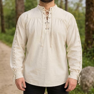 May include: An off-white long-sleeve shirt featuring a lace-up front closure with metal grommets and matching cord ties. The sleeves are detailed with vertical lace-up accents running from the shoulder to the cuff, which also features ties.