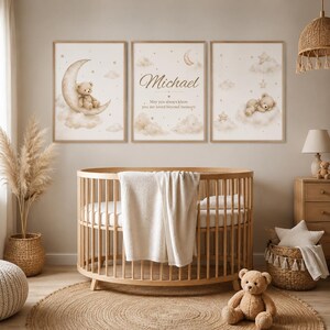 Puede incluir: Una escena de guardería con tres impresiones enmarcadas con osos de peluche, lunas y nubes. La impresión central muestra el nombre "Michael" y una cita. Una cuna de madera, una alfombra y un oso de peluche están en primer plano, creando un ambiente acogedor.