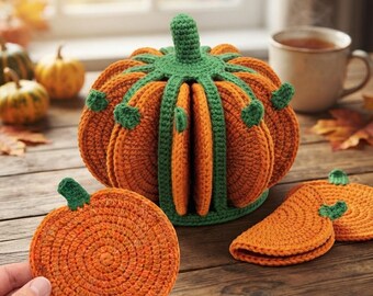 May include: A crochet pumpkin-shaped holder containing several orange pumpkin-shaped coasters. The holder features a green stem and green vertical ribs that separate the individual coasters. Each coaster is round with a small green stem.