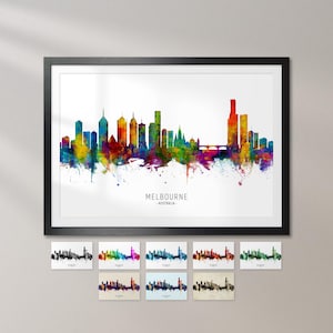 The image is a framed watercolor painting of the Melbourne skyline, with various color variations of the city's buildings depicted in a stylized manner.