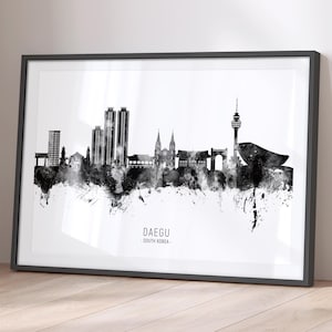 May include: Black and white framed print of the Daegu, South Korea skyline. The artwork features a watercolor effect with the city's buildings and landmarks in silhouette. The text "DAEGU - SOUTH KOREA" is printed at the bottom.