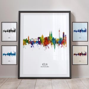 May include: A watercolour cityscape of Cologne, Germany. The skyline is depicted in vibrant colours, with Cologne Cathedral and other prominent buildings visible. The text "KÖLN - DEUTSCHLAND -" is printed below the cityscape.
