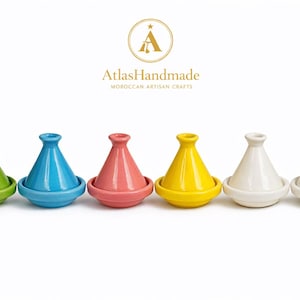 Puede incluir: Seis tagines de cerámica de colores, cada uno con una tapa cónica y una base circular. Los tagines son de color verde, azul, rosa, amarillo y blanco. El logotipo "Atlas Handmade Moroccan Artisan Crafts" está en la parte superior.