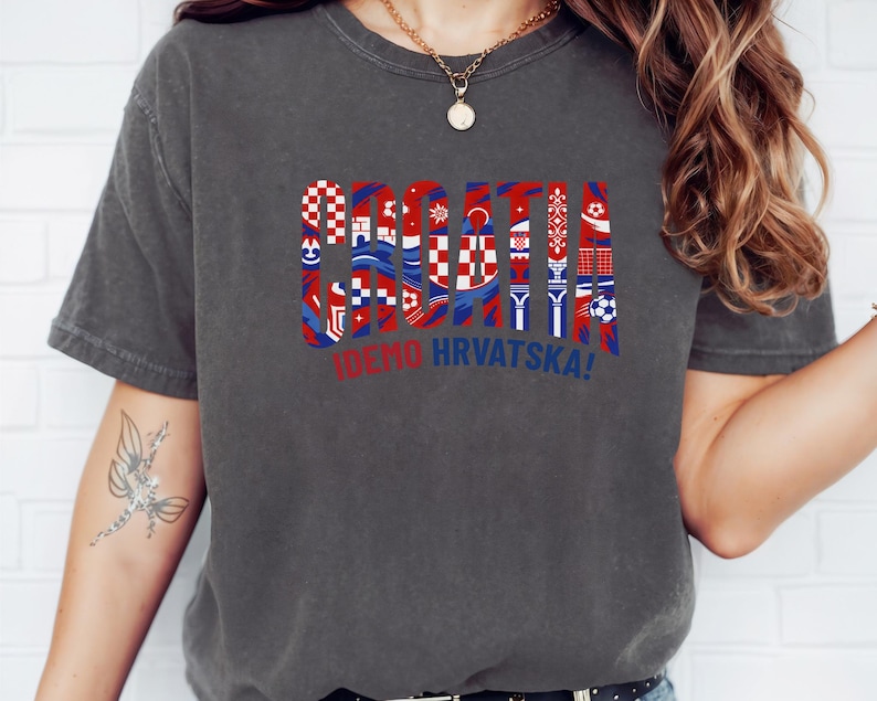 A person wearing a gray t-shirt with a graphic design featuring the flag of Croatia and the text "IWEND HRVATSKA!"