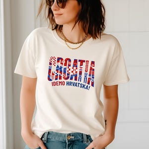 A woman wearing a white t-shirt with a graphic design and text printed on it.