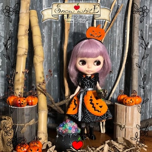 Könnte beinhalten: Eine Puppe in einem Halloween-Kostüm mit einem schwarz-orangen Kleid, einem Kürbis-Haarreif und einer kürbisförmigen Schürze. Die Puppe hat lila Haare und steht vor einem hölzernen Hintergrund mit Kürbissen. Der Text "Snow white E" ist sichtbar.