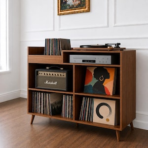May include: A wooden media console with tapered legs featuring multiple storage compartments. The unit holds a turntable, a CD player, a Marshall amplifier, and several vinyl records with various cover art designs arranged on the shelves.