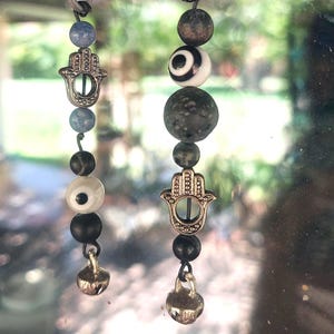 Evil Eye ward charm with hamsa hand, stone beads, and bell.  Suction hook included