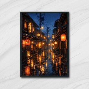 Könnte beinhalten: Gerahmter Kunstdruck einer japanischen Straßenszene bei Nacht im Regen. Traditionelle Holzhäuser mit beleuchteten Laternen und Schildern säumen die Straße. Das nasse Kopfsteinpflaster reflektiert das warme Licht und erzeugt eine Stimmung.