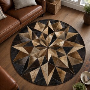 Puede incluir: Una alfombra circular con un patrón geométrico de estrella compuesto por paneles cosidos en tonos marrón, bronceado y negro. El diseño consiste en formas triangulares radiantes que se encuentran en un punto central, creando un efecto visual complejo.