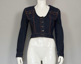 May include: A dark blue denim jacket with orange stitching and a button closure. The jacket has a cropped length and a fitted silhouette.