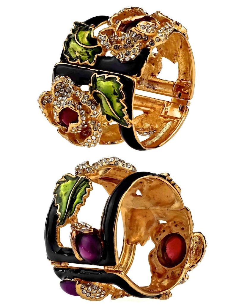 Puede incluir: Un par de pulseras de tono dorado con esmalte negro y detalles de esmalte de colores. Las pulseras est&aacute;n decoradas con diamantes de imitaci&oacute;n y presentan un dise&ntilde;o floral.