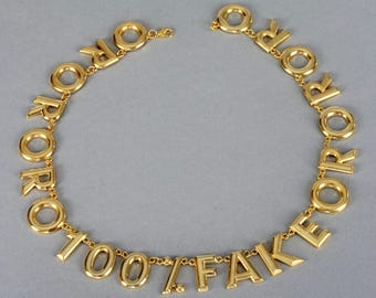 Collana vintage MOSCHINO "ORO 100% FAKE" con scritta "Novità"