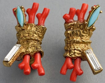 May include: A pair of gold tone earrings with coral and turquoise accents. The earrings feature a textured gold design with a cluster of coral branches and turquoise stones.
