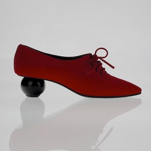 May include: Red satin lace-up shoes with a black ball heel.