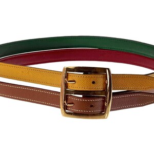 Pode incluir: Um cinto de couro multicolorido com uma fivela dourada. O cinto &eacute; feito de tr&ecirc;s cores diferentes de couro: marrom, amarelo e verde.