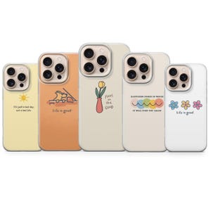Pode incluir: Uma coleção de cinco capas de telefone com vários designs e citações. As capas apresentam um sol amarelo, um desenho de um cão, uma tulipa num vaso, um arco-íris e três flores. Cada capa tem uma citação diferente, incluindo "É só um dia ruim, não uma vida ruim."