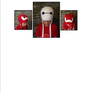 May include: Two children wearing crocheted hats. One hat is white with a black face and the other is red with a black face. Both children are wearing red shirts.