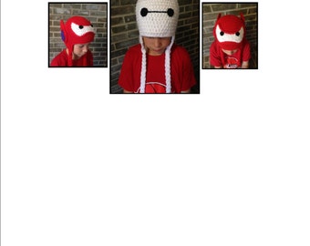 May include: Two children wearing crocheted hats. One hat is white with a black face and the other is red with a black face. Both children are wearing red shirts.