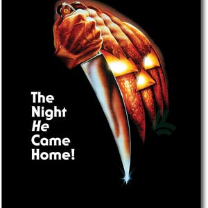 Peut inclure: Une affiche de film pour Halloween montrant une grande citrouille orange sculptée aux yeux brillants tenue par une main agrippant un couteau argenté. Le texte indique HALLOWEEN, The Night He Came Home!, avec les crédits de production en bas.