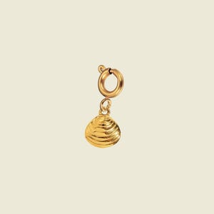 May include: A gold-toned metal charm in the shape of a small, ribbed seashell. The charm is attached to a circular spring ring clasp, which allows it to be easily clipped onto a chain, bracelet, or other jewelry piece for decorative purposes.