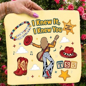 May include: A light yellow fabric square featuring the text I Knew It, I Knew You, a beaded bracelet with the text You've Got A Friend In Me, a sheriff star with Infinity And Beyond, a person with a guitar, cowboy boots, and a red hat.