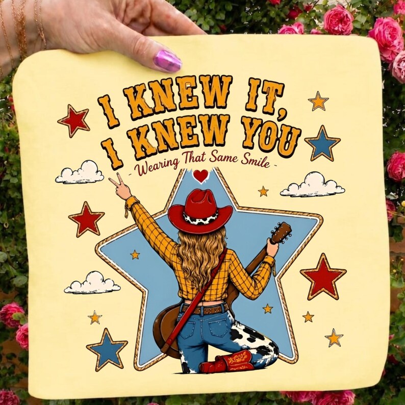 May include: A light yellow fabric square featuring a graphic of a person in a red cowboy hat, yellow plaid shirt, and cow-print jeans holding a guitar. The text reads I KNEW IT, I KNEW YOU, Wearing That Same Smile, surrounded by stars and clouds.