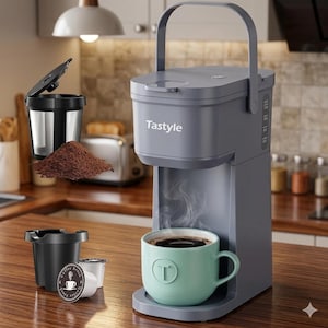 Puede incluir: Una cafetera individual Tastyle de color gris pizarra con asa superior, que incluye una taza verde claro con un logotipo T bajo el surtidor. Se incluyen un filtro de malla negra reutilizable, café molido y una cápsula de café blanca.