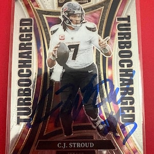 May include: A 2021 Select football trading card featuring C.J. Stroud of the Texans. The card has a silver and black design with the words "Turbocharged" and the player's name and team. The card is encased in a protective sleeve.