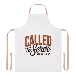 Op de afbeelding: Witte schort met beige bandjes en nekband. De schort heeft de tekst "CALLED to Serve" in bruin en zwart schrift, met "MARK 10:45" eronder. Een keuken- of kookaccessoire.
