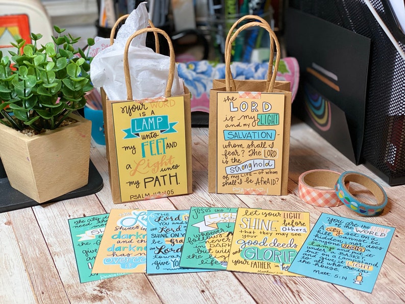 May include: A set of six small cards with inspirational bible verses written in colorful lettering. The cards are decorated with a variety of colors, including blue, green, yellow, and orange. The cards are perfect for adding a touch of faith to your home or office.