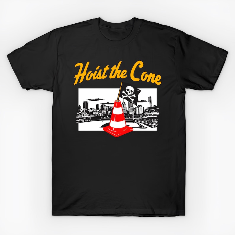 Puede incluir: Camiseta negra con un gr&aacute;fico que presenta un cono de tr&aacute;fico rojo y blanco, una bandera pirata y un paisaje urbano. El texto "Hoist the Cone" est&aacute; en escritura amarilla encima del gr&aacute;fico.