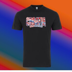May include: Black crew neck t-shirt with the word "CROATIA" in a red, white, and blue design, with the text "IDEMO HRVATSKA!" below. The shirt is a solid black color.
