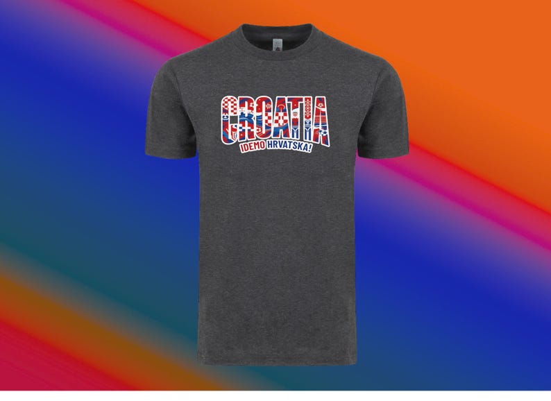 May include: Dark gray t-shirt with the word "CROATIA" in a red, white, and blue design, with the text "IDEMO HRVATSKA!" below. The shirt has a crew neck and short sleeves.
