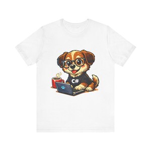 May include: White t-shirt featuring a cartoon dog wearing glasses and a black shirt with "C#" on it. The dog is sitting in front of a laptop with a paw print on the screen, and a red mug is next to it.