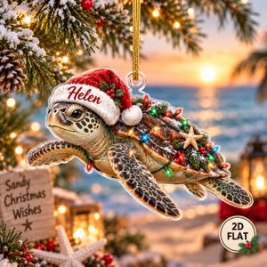 May include: A flat, clear acrylic Christmas ornament shaped like a sea turtle wearing a red Santa hat with the name Helen printed on the brim. The turtle is decorated with green pine branches, a small starfish, and colorful string lights.