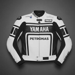 Puede incluir: Una chaqueta de moto en blanco y negro con el logotipo de Yamaha en el pecho y las mangas, y la marca Petronas en la parte delantera. La chaqueta incluye un cuello mao, cierre de cremallera frontal y una correa de ajuste en la cintura.