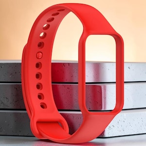 Könnte beinhalten: Ein leuchtend rotes Ersatz-Uhrenarmband. Das Armband besteht aus einem flexiblen Material und verfügt über eine Reihe von Einstelllöchern. Es hat einen rechteckigen Rahmen für das Zifferblatt. Das Armband ist für das Tragen am Handgelenk konzipiert.