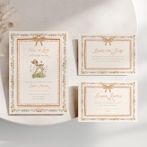 Puede incluir: Un juego de tres tarjetas de papel color crema con una ilustración de un cervatillo, bordes florales y texto marrón. La tarjeta más grande dice Fall in Love with Baby Miller, y las pequeñas Books for Baby y Diaper Raffle.