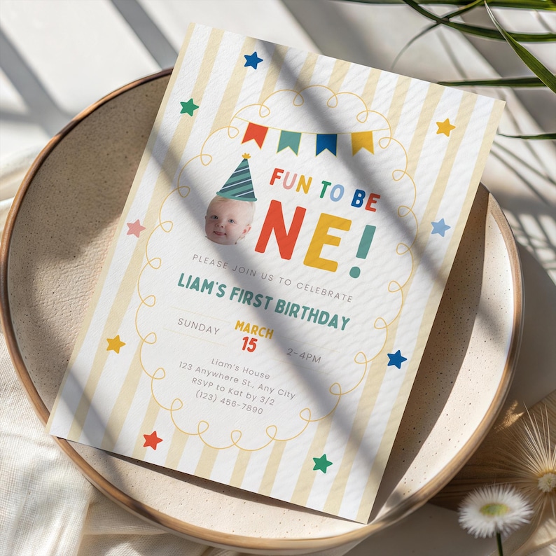 K&ouml;nnte beinhalten: Eine Geburtstagseinladung mit Babyfoto, farbenfrohem Text und Stern- und Bannerdekorationen. Die Einladung lautet "FUN TO BE ONE!" und k&uuml;ndigt Liams ersten Geburtstag am 15. M&auml;rz an.