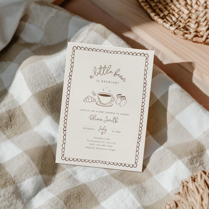 May include: A beige baby shower invitation with a scalloped border. The text reads "a little bean is brewing!" with illustrations of a coffee cup, croissant, and baby socks. Details include the honoree's name, date, time, and location.
